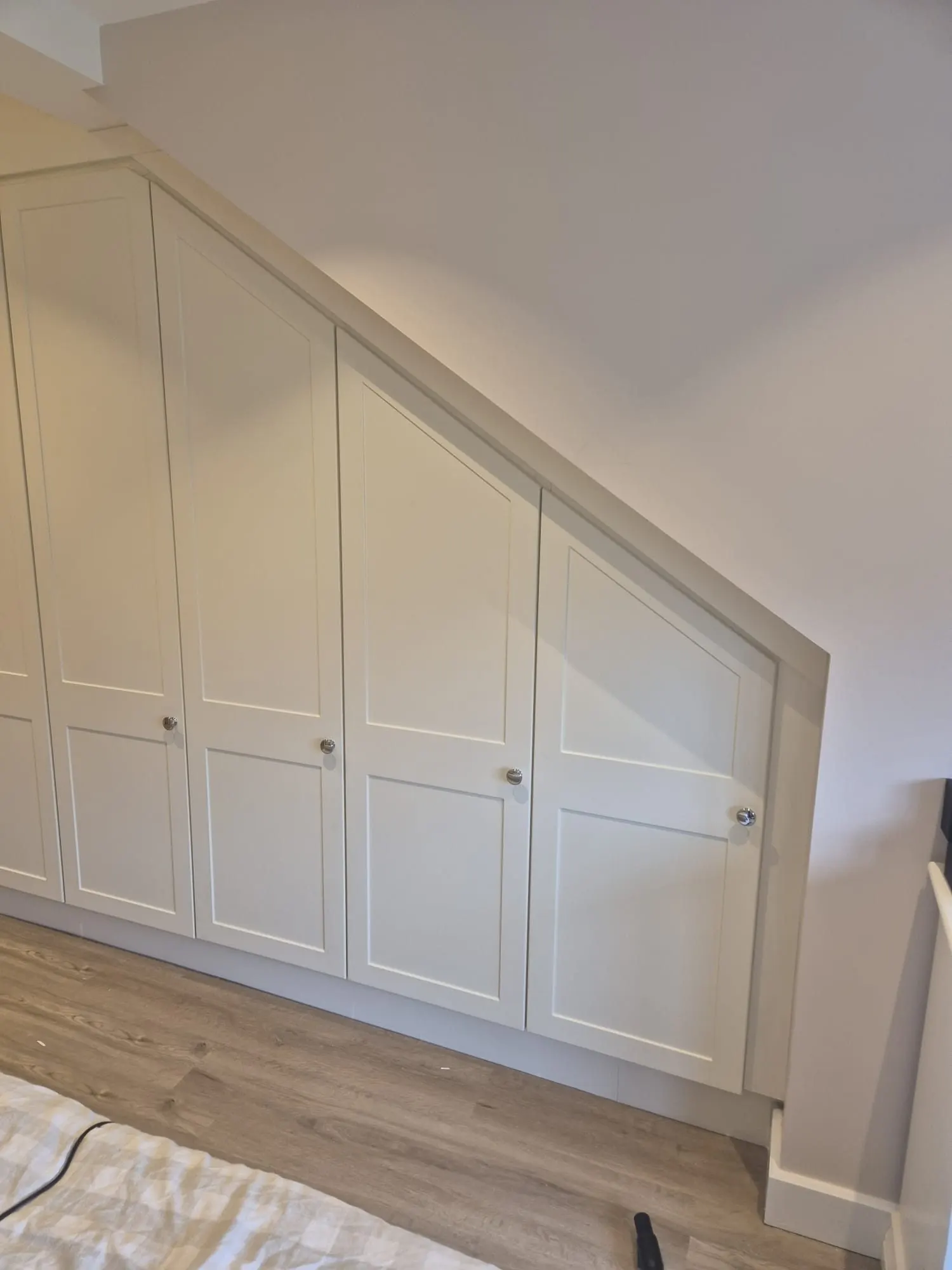 Fitted wardrobe doors scribed to a sloping ceiling, installed by CKC